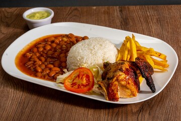 Deliciously charred and smoky Pollo a la Brasa (grilled chicken) served whole and in pieces, accompanied by crispy fries, fresh salad, and a flavorful dipping sauce. A classic Latin American dish, coo