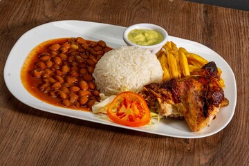 Deliciously charred and smoky Pollo a la Brasa (grilled chicken) served whole and in pieces, accompanied by crispy fries, fresh salad, and a flavorful dipping sauce. A classic Latin American dish, coo