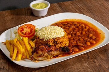 Deliciously charred and smoky Pollo a la Brasa (grilled chicken) served whole and in pieces, accompanied by crispy fries, fresh salad, and a flavorful dipping sauce. A classic Latin American dish, coo