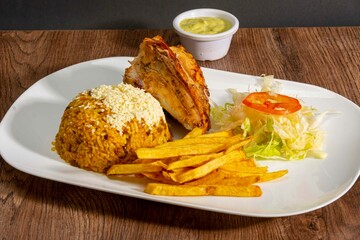 Deliciously charred and smoky Pollo a la Brasa (grilled chicken) served whole and in pieces, accompanied by crispy fries, fresh salad, and a flavorful dipping sauce. A classic Latin American dish, coo