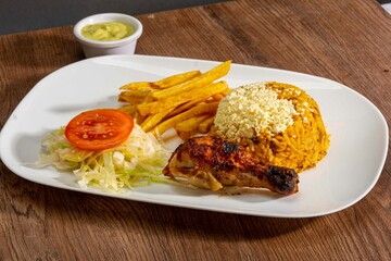 Deliciously charred and smoky Pollo a la Brasa (grilled chicken) served whole and in pieces, accompanied by crispy fries, fresh salad, and a flavorful dipping sauce. A classic Latin American dish, coo