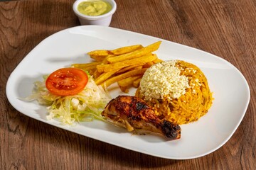 Deliciously charred and smoky Pollo a la Brasa (grilled chicken) served whole and in pieces, accompanied by crispy fries, fresh salad, and a flavorful dipping sauce. A classic Latin American dish, coo
