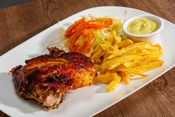 Deliciously charred and smoky Pollo a la Brasa (grilled chicken) served whole and in pieces, accompanied by crispy fries, fresh salad, and a flavorful dipping sauce. A classic Latin American dish, coo