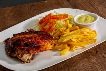 Deliciously charred and smoky Pollo a la Brasa (grilled chicken) served whole and in pieces,...