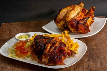 Deliciously charred and smoky Pollo a la Brasa (grilled chicken) served whole and in pieces, accompanied by crispy fries, fresh salad, and a flavorful dipping sauce. A classic Latin American dish, coo