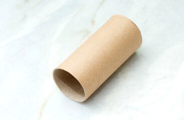 An empty toilet paper roll lies on a table in a bathroom