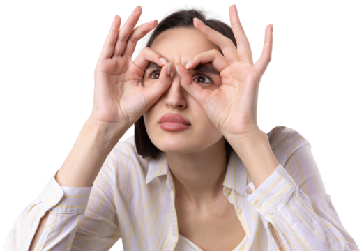 Close up portrait of attractive quirky young woman making binoculars with hands showing ok gesture on white studio background.