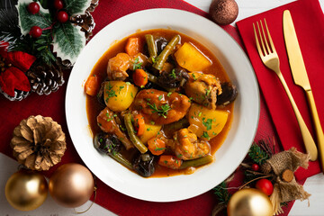 Delicious Rabbit stewed with vegetables and potatoes. Top view table with christmas decoration.