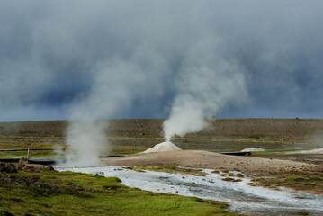 Geothermal Hot Springs in Lush Green Icelandic Landscape with Rising Steam