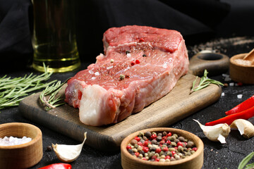 Raw meat on a cutting board with spices. Steak. Cooking.