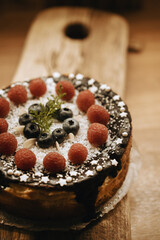 cake with blueerries and raspberries on wooden background