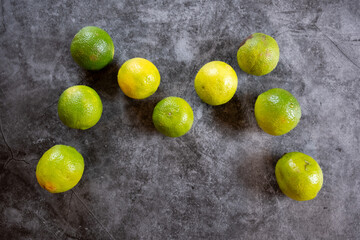 Limettten bilden den Buchstaben M auf grauen Hintergrund 