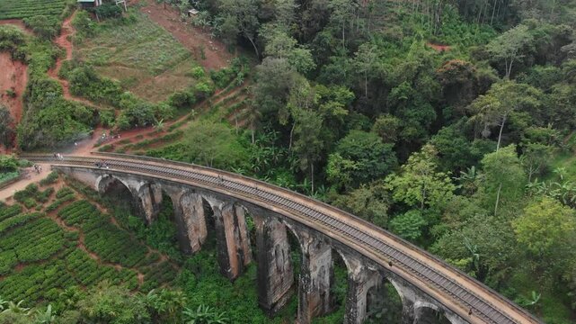 Aerial view of the iconic nine arches bridge surrounded by lush tea fields and jungle, Ella, Sri Lanka.