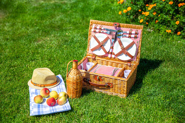 Picnic basket on green sunny lawn in the park