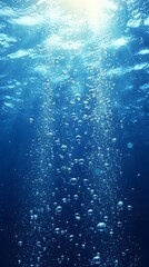 Underwater view of blue water with bubbles and sunlight shining through, creating an underwater scene
