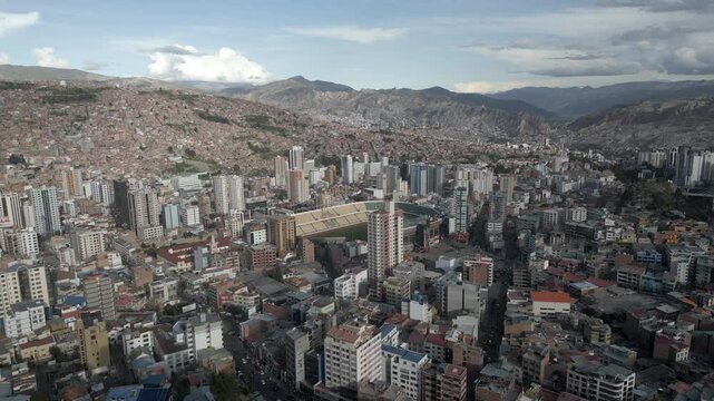 Aerial view of bustling La Paz with Hernando Siles Stadium and mountainous skyline, La Paz, Bolivia.