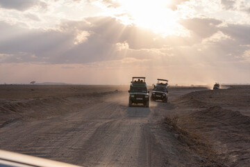 jeep trip on savanna road at sunset, safari in amboseli national park, kenya, africa