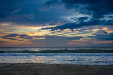 Fototapeta premium Beautiful scenery by the sea. The sun with colored clouds from the sunrise, in the morning.