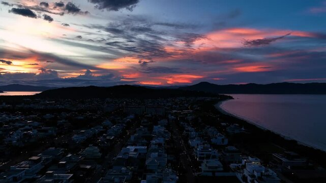 Aerial view of sunset over the tropical town of Jurere with a picturesque coastline and colorful sky, Florianopolis, Brazil.