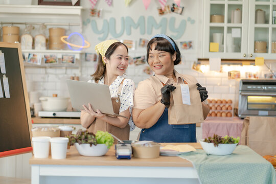 Beautiful asian sisters sell online bakery shop at home,family business,online influencer,start-up business.happyness Beautiful woman to take orders from customers,live-stream their sandwiches online - Powered by Adobe