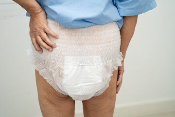 Asian elderly woman wearing diaper for loss of bladder urinary incontinence control.