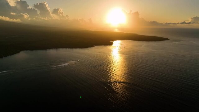 Aerial view of a serene tropical island at sunrise with clouds reflecting on the tranquil ocean, Tuamasaga, Samoa.