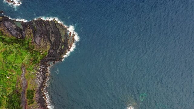 Aerial view of the beautiful coastline with rocky cliffs and azure ocean, Sao Jorge, Azores, Portugal.