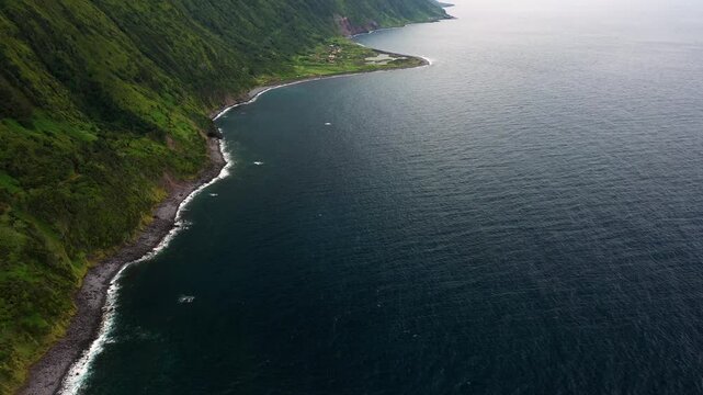 Aerial view of the breathtaking coastline with rugged cliffs and lush greenery, Sao Jorge, Azores, Portugal.