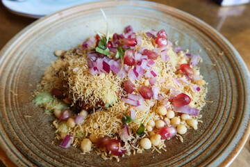 close up of Indian Aloo Tikki Chaat
which includes spicy crispy fried potato  patties topped with chutneys, curd, chaat masala on a plate