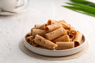Khanom Thong Muan, crispy egg roll,Thai sweetmeat made of flour, coconut milk and egg in white bowl
