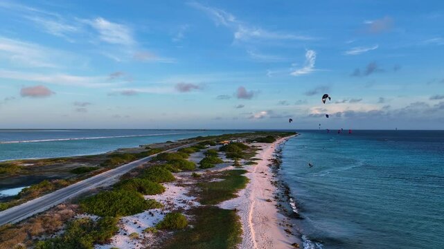 Aerial view of a beautiful tropical island with kitesurfers on the ocean and sandy beach, Caribbean.
