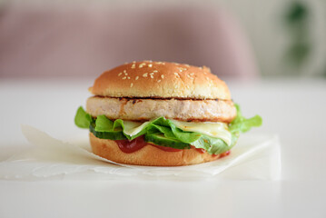 Homemade cheeseburger on white table. Front view