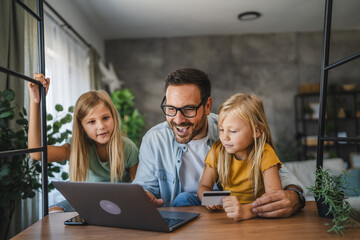 Father and daughters have online shopping on laptop with credit card