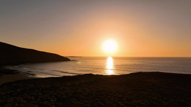 Aerial view of serene sunrise over the ocean with a picturesque beach and coastline, Arico, Spain.