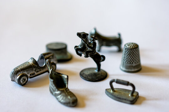 Original Monopoly markers including horse, iron, shoe, car, hat, dog, and thimble on white background.