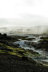 Geothermal Hot Springs in Lush Green Icelandic Landscape with Rising Steam