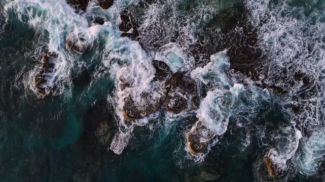 Aerial view of tropical island reef with crashing waves and vibrant blue ocean, Tongatapu, Tonga.