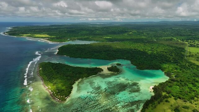 Aerial view of a tropical island with lush greenery and pristine reef surrounded by azure waves, Shefa Province, Vanuatu.