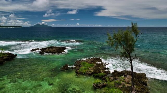 Aerial view of a beautiful tropical island with azure waters, palm trees, and crashing waves, Shefa Province, Vanuatu.