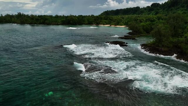 Aerial view of a beautiful tropical island with serene waves, lush palms, and a tranquil beach, Shefa Province, Vanuatu.