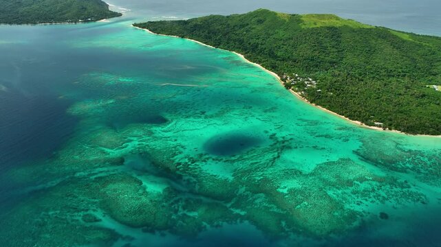 Aerial view of a beautiful tropical island with a serene lagoon and lush palms, Shefa Province, Vanuatu.