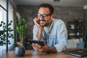 Adult man with eyeglasses use and watch a cellphone while sit at home