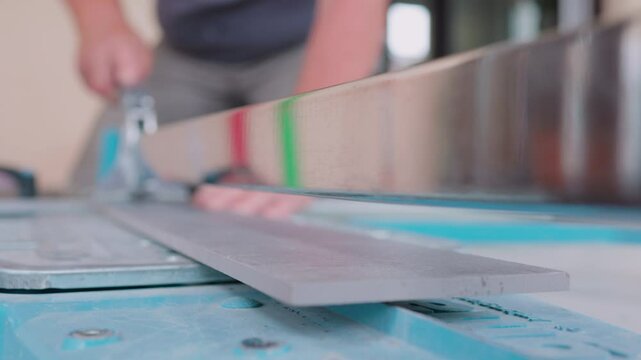 Fliesenleger schneidet Fliese