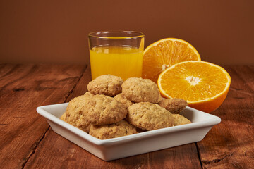 Homemade orange-flavored cookies accompanied by a glass of fresh orange juice