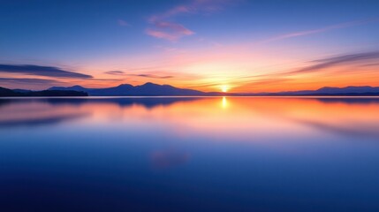 Fototapeta premium A serene sunset over a calm lake, reflecting vibrant colors in the water.