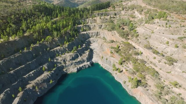 Aerial view of highbury quarry with serene blue lake surrounded by green forest and majestic mountains, adelaide, south australia.