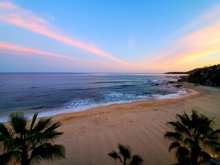 sunset on the beach, colorful clouds, sandy beach, ocean waves