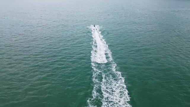 Aerial view of jetskis racing on the beautiful ocean waves at Pantai Cenang, Kuah, Malaysia.