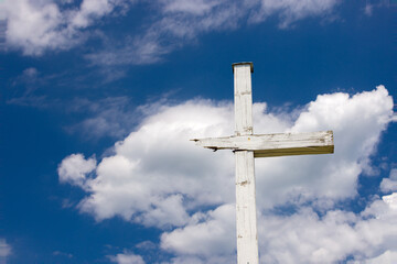 Cracked wooden cross against the sky.