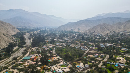 South American suburban landscape in a desertic valley surrounded by mountains during the afternoon taken from drone